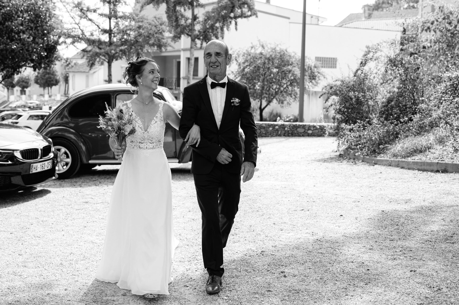 Arrivée d'Audrey en 2CV au bras de son père à la mairie d'Hagetmau - Photographe mariage Landes [cite: Je suis photographe professionnel basé dans les Landes au 35 Rue du Bellocq à Saint Sever, spécialisé dans les mariages, les séances famille, grossesse, portraits et photographie immobilière. Je travaille principalement avec des couples et des familles sensibles à la nature, à l’océan et aux traditions locales.]