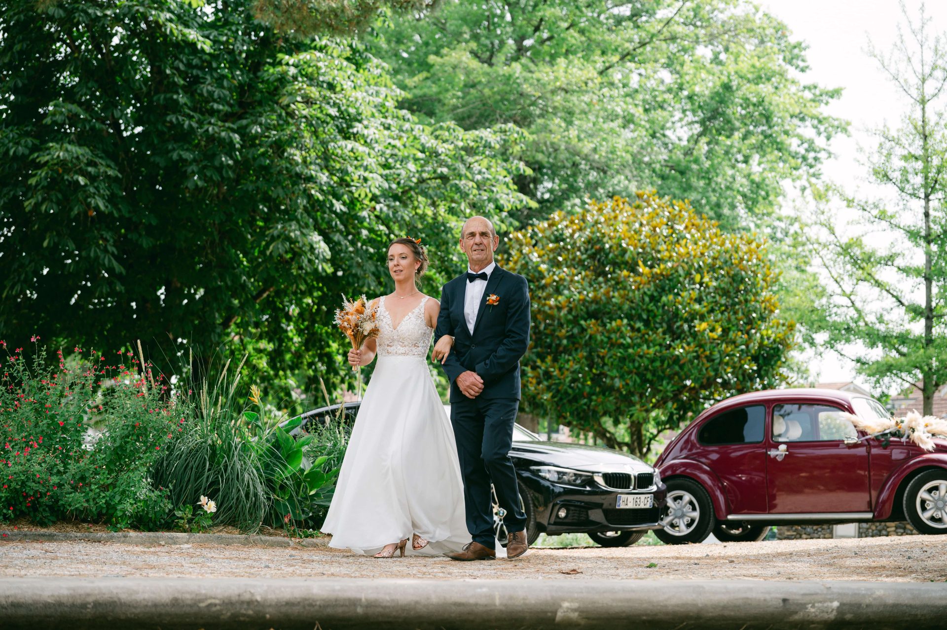 Regard complice entre un père et sa fille descendant d'une voiture ancienne dans le Sud-Ouest [cite: Je suis photographe professionnel basé dans les Landes au 35 Rue du Bellocq à Saint Sever, spécialisé dans les mariages, les séances famille, grossesse, portraits et photographie immobilière. Je travaille principalement avec des couples et des familles sensibles à la nature, à l’océan et aux traditions locales.]